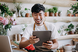 Asian Florist with tablet at counter
