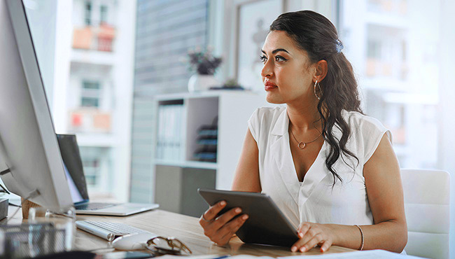 Woman at office with tablet and computer