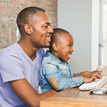 Father playing on the computer with a child