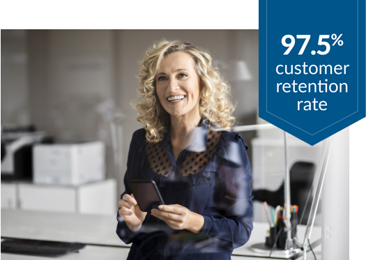 Woman in office setting holding cell phone